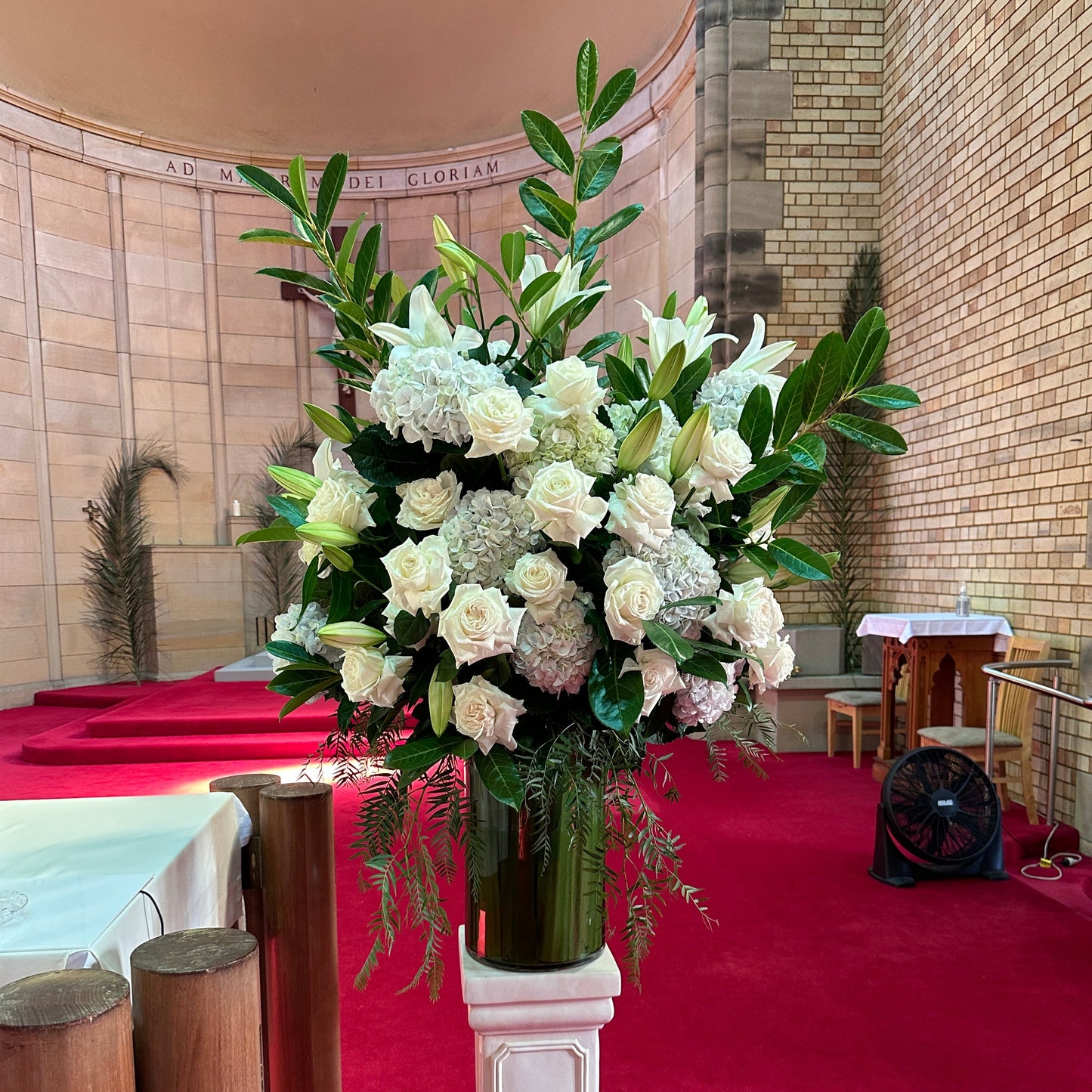 A stunning Large Chapel Vase Arrangement by Flowers on Norton St, featuring seasonal florals, graces the church.