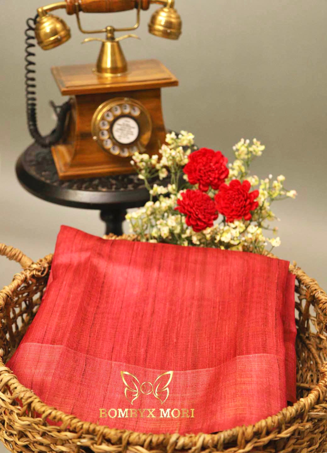 A captivating Neon Crush arrangement by Flowers on Norton St beautifully displays a vivid combination of red roses, purple dahlias, bright pink roses, and vibrant blue asters, all nestled in a gold vase. The textured light gray wall in the background provides a subtle contrast to the lively bouquet.