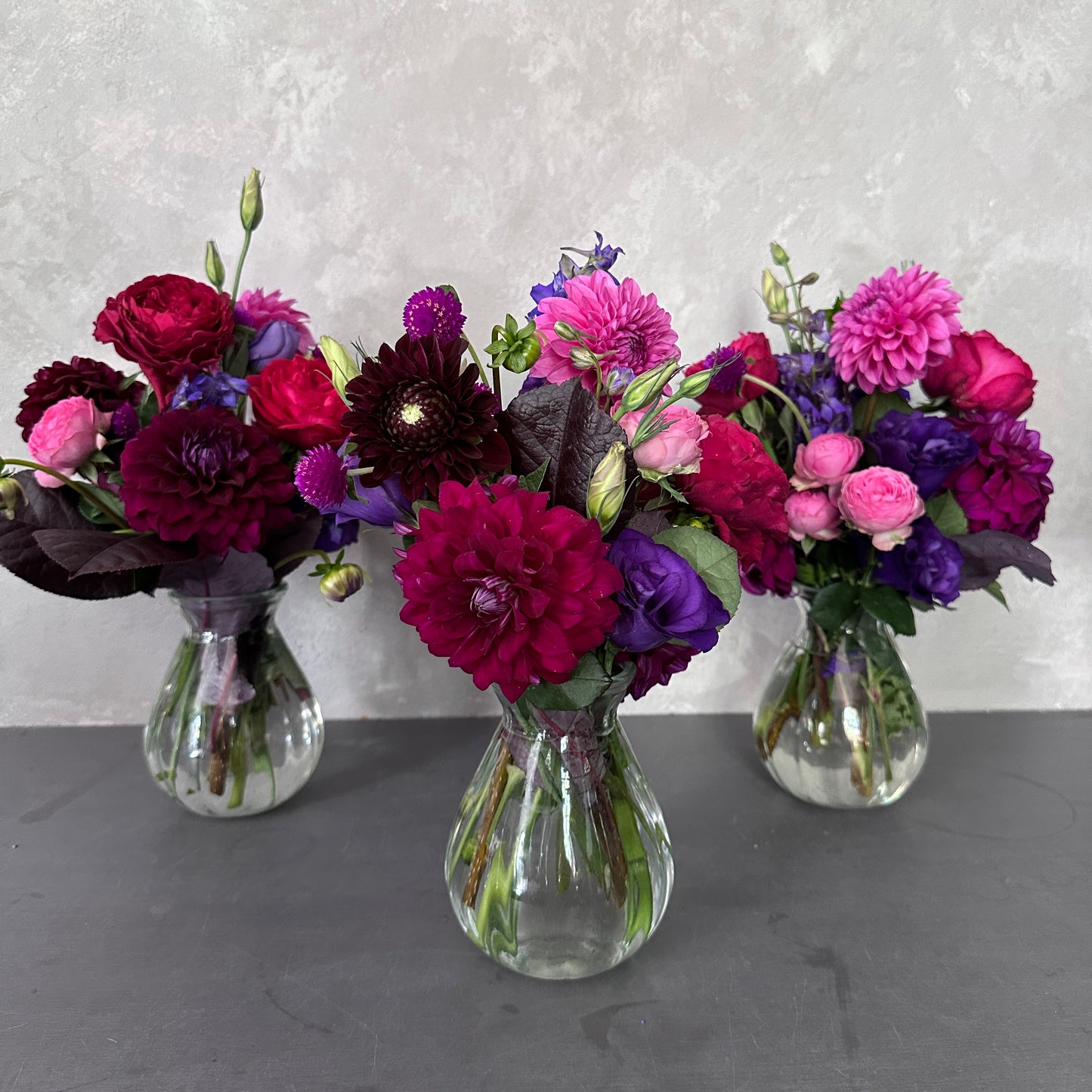 A delightful table centerpiece featuring a group of seasonal blooms elegantly arranged in Lovely Vintage Vases by FlowersonNortonSt from Australia.